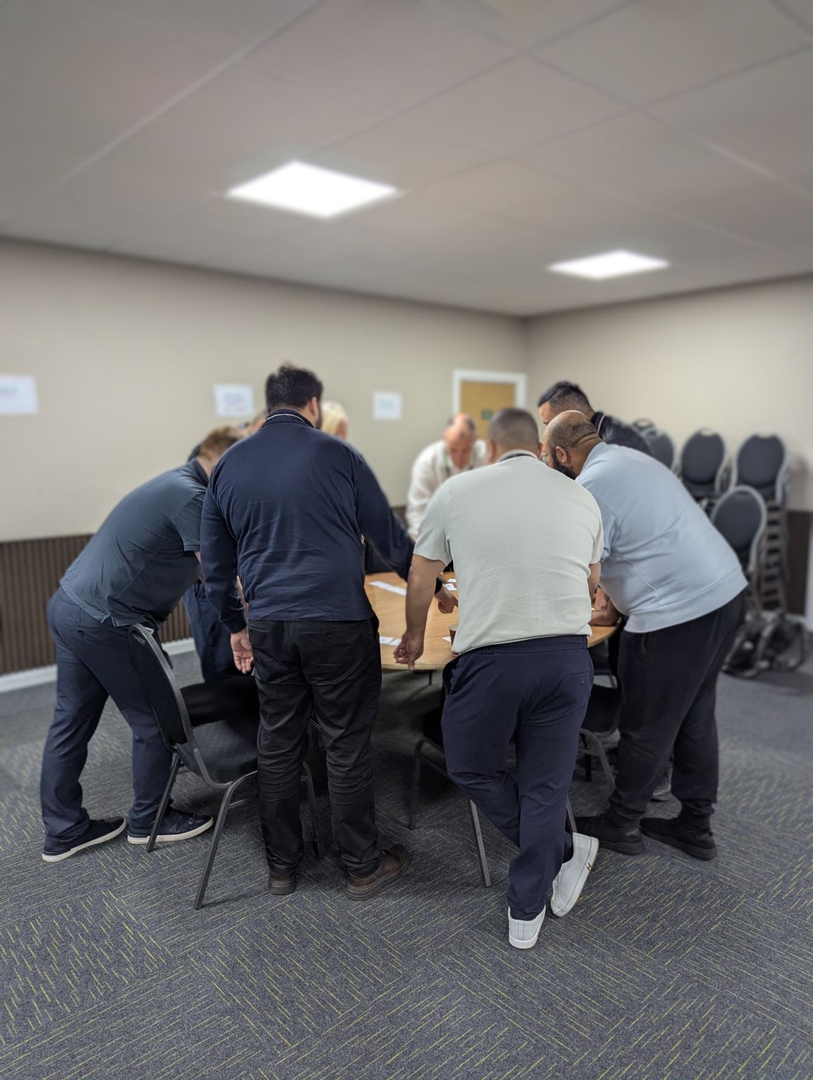A leadership team gathered round a table, working through a card activity together