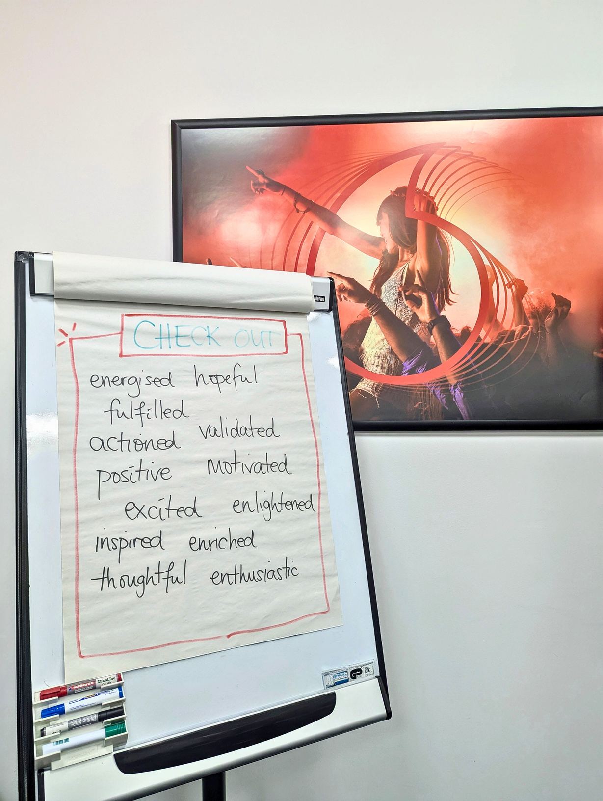 A workshop flipchart headed Check out, listing words such as energised, hopeful, validated and inspired